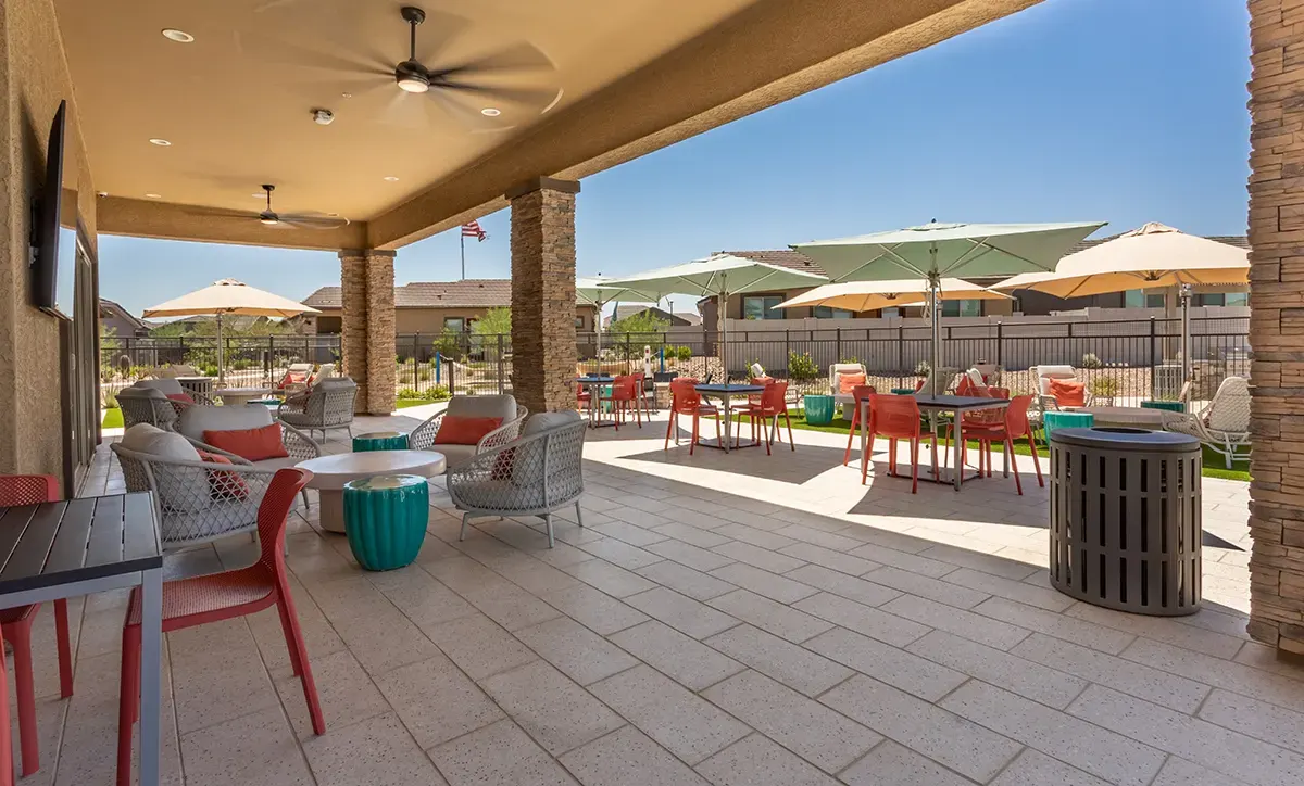 Covered patio lounge beside the pool at Village Sonoran Vista.