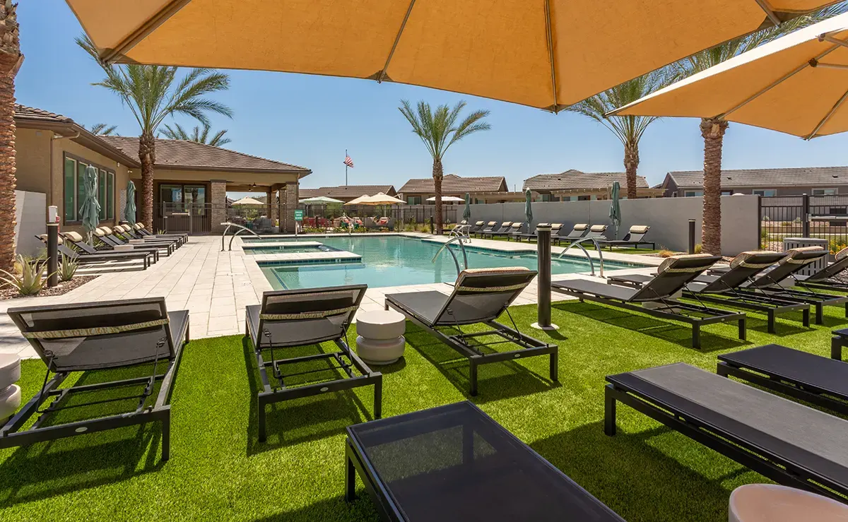 Poolside loungers under umbrellas at Village Sonoran Vista.