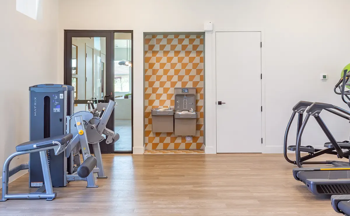 Exercise room and drinking fountain at Village Sonoran Vista.