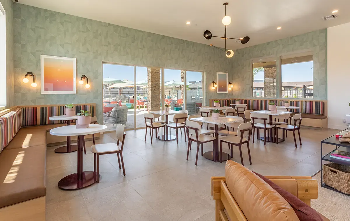 Shared tables beside clubhouse windows at Village Sonoran Vista.