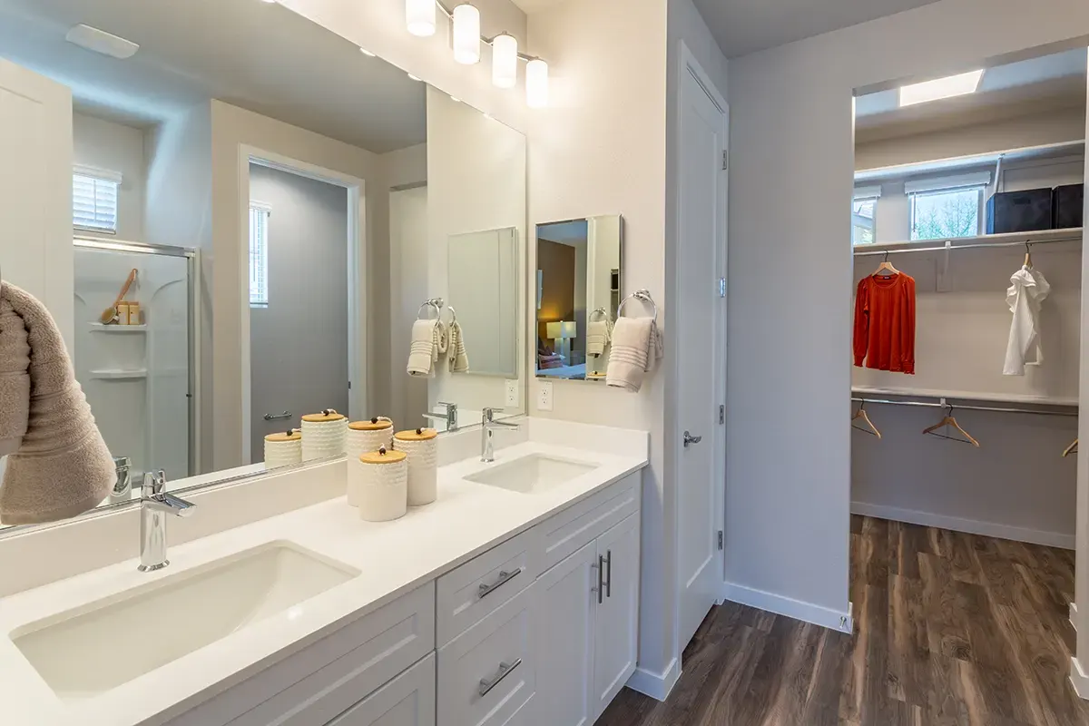 Double-sink bathroom vanity and closet doorway at Village Sonoran Vista.