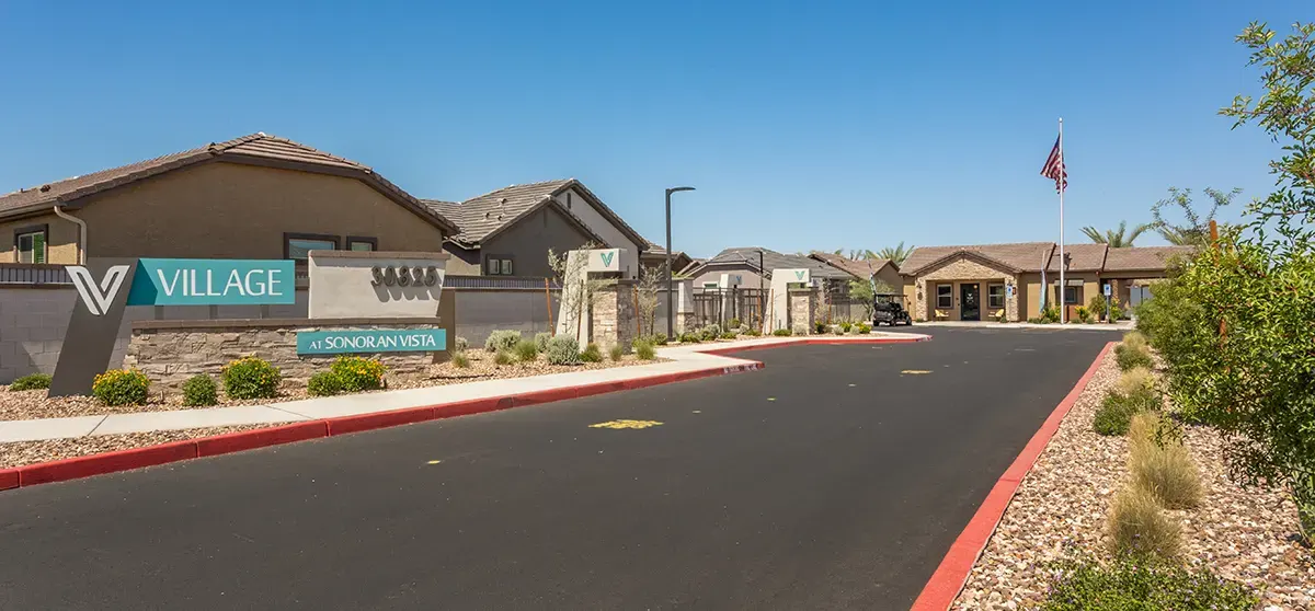 Entry driveway and community sign at Village Sonoran Vista.